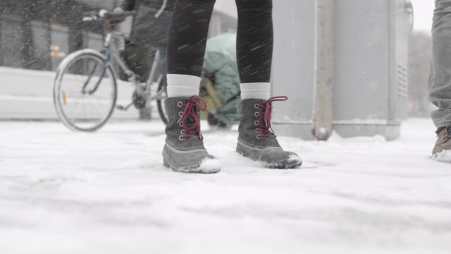 近距离拍摄下雪时的两双脚视频素材