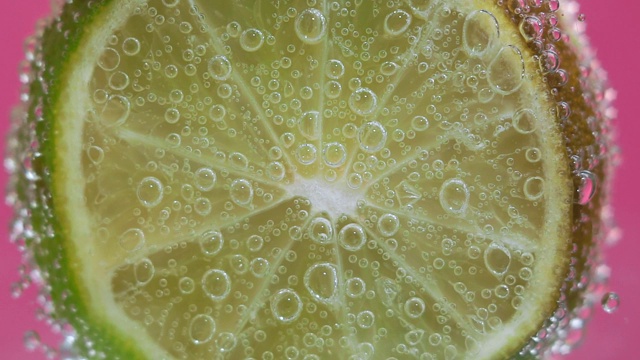 在水中的酸橙水果在水中有气泡。多汁的柑橘特写，微距。有选择性的重点。视频素材