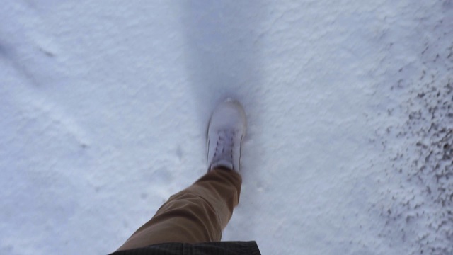 冬天，穿着白色运动鞋的人在雪地里行走视频素材