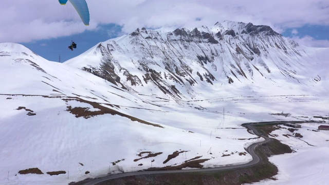 滑翔伞在雪山中飞行。视频素材