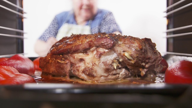 女人在烤箱里烤蔬菜猪颈肉，肥肉视频素材