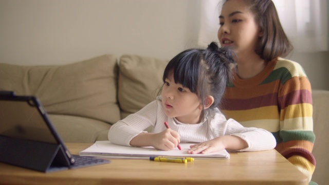 亚裔女儿在家和母亲一起参加网络课程。视频素材