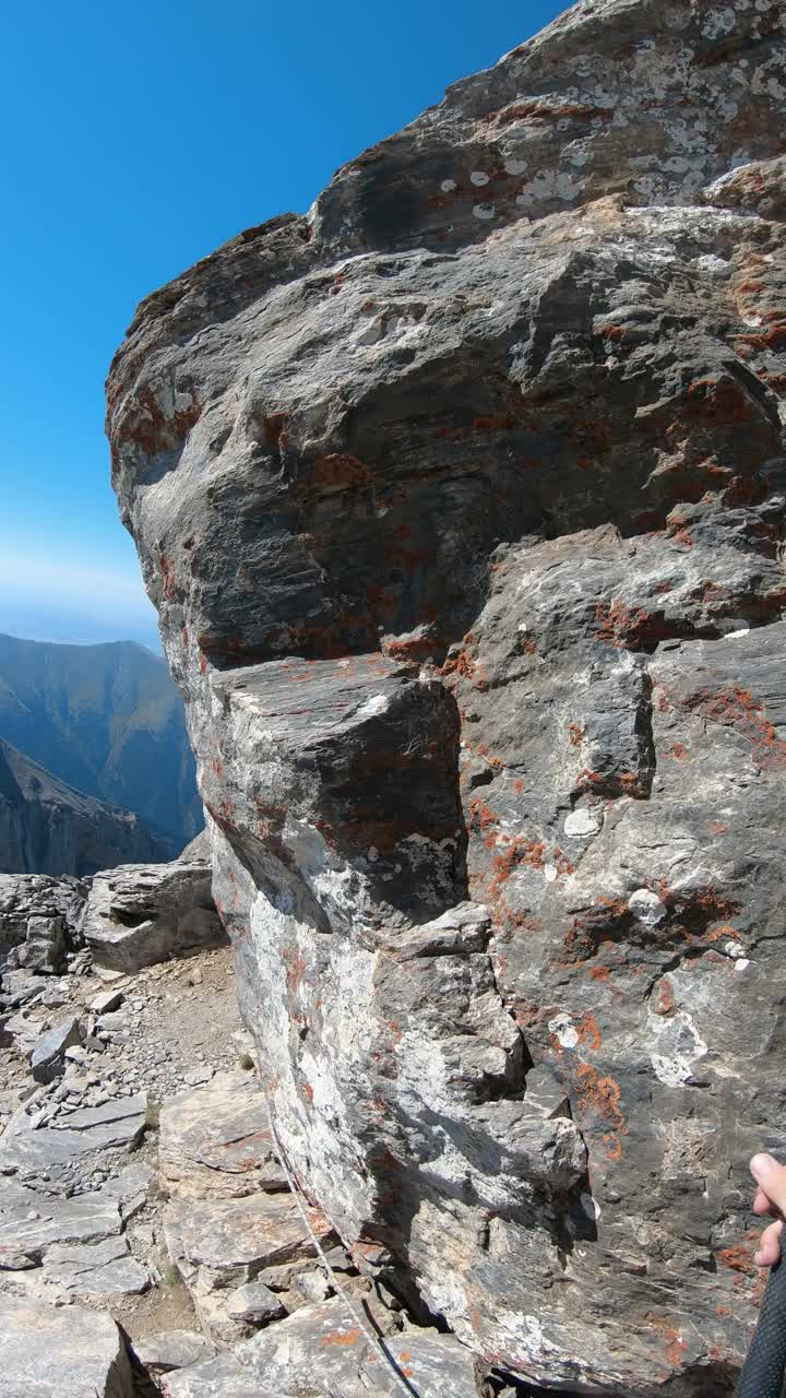 登山家波夫前往希腊奥林匹斯山的米提卡斯岩石山顶探险，垂直方向视频素材