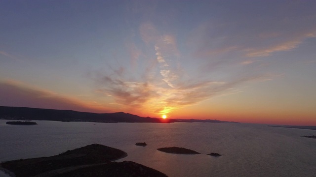 空中平移拍摄的海洋中的小岛屿对天空日落，无人机飞过美丽的自然景观-心岛，克罗地亚视频素材