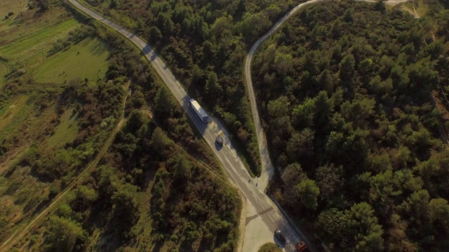 空中倾斜拍摄公路上绿树成荫的车辆，无人机在阳光明媚的日子里飞过风景——克罗地亚的拉扎纳克视频素材