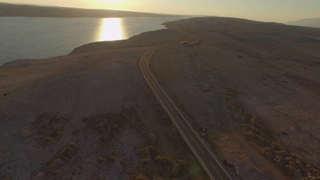 空中拍摄的道路与海上的车辆对天空，无人机在日落景观向前飞行-拉扎纳克，克罗地亚视频素材