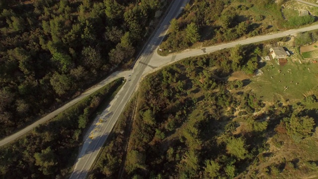 航拍建筑物附近的绿树中间的道路，在一个阳光明媚的日子里，无人机在高速公路上向前飞行——拉扎纳克，克罗地亚视频素材