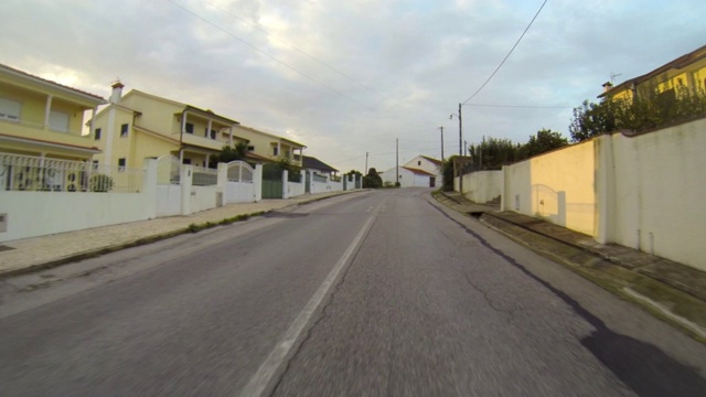 日落时分，在多云天空下的房屋中间的道路上拍摄的POV - Figueira da Foz，葡萄牙视频素材