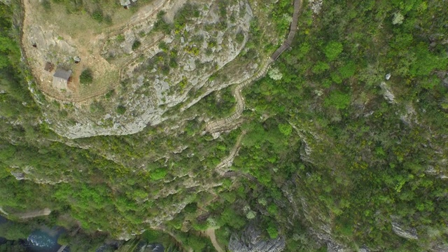 航拍的河流由岩石山与绿色植物在森林，无人机飞过水流动的山谷-克尔卡，克罗地亚视频素材