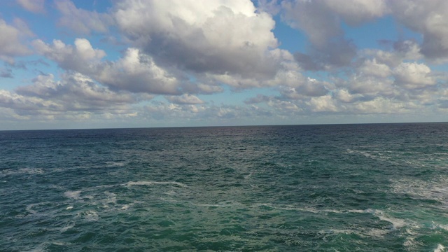 航拍海浪在阳光明媚的一天天空，无人机向前飞在岩石海岸线-卡莱斯德马略卡，西班牙视频素材