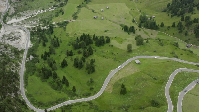 空中拍摄的车辆在蜿蜒的道路上的绿色景观，无人机在高速公路上向前飞行- Dolomites，意大利视频素材