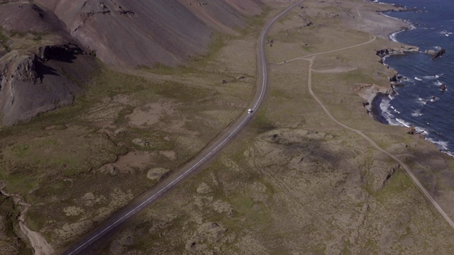 航拍的车辆移动的道路中山和海，无人机下降到露营车-冰岛西南部，冰岛视频素材