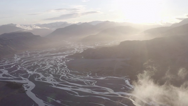 空中平移拍摄的风景优美的河流三角洲和山脉对天空，无人机飞越景观在晴朗的一天-冰岛西南部，冰岛视频素材