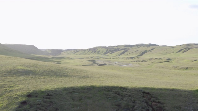 空中拍摄的岩石悬崖峡谷对晴朗的一天，无人机上升时，向前飞向河流和绿色的山脉-冰岛西南部，冰岛视频素材