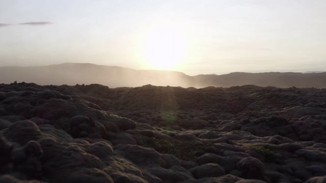 航拍:夕阳下的岩石景观，无人机朝着山脉的轮廓飞行——冰岛西南部视频素材