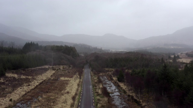 航拍的空道路的小溪和树木对天空，无人机上升的同时飞向山脉-冰岛西南部，爱尔兰视频素材