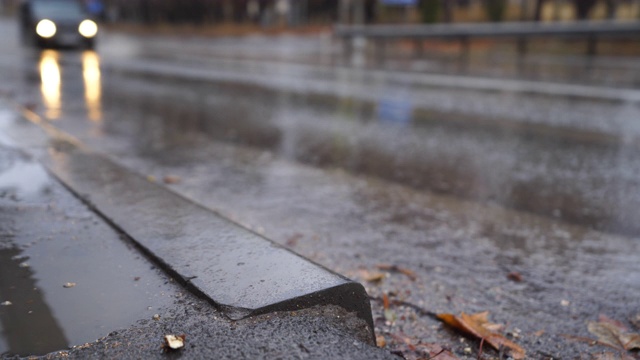 在秋天的雨天，在潮湿的道路上模糊的城市交通。视频素材