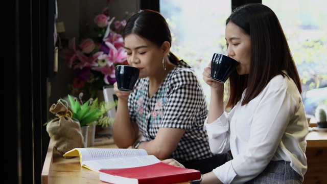 两个亚洲女人喝咖啡和愉快的女人闲谈在咖啡馆视频素材