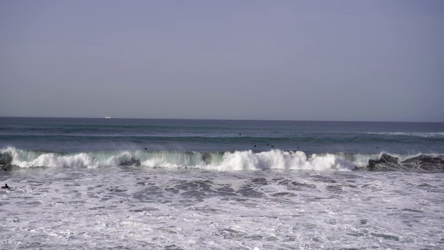 海洋在海滩上编织，人们在游泳和冲浪视频素材