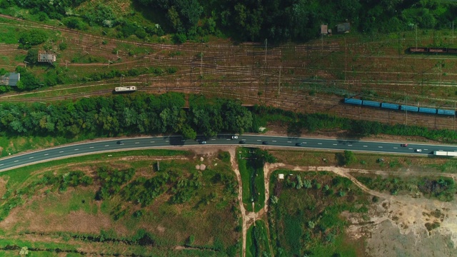 俯视图上的许多铁路轨道和火车沿着乡村公路行驶。视频素材