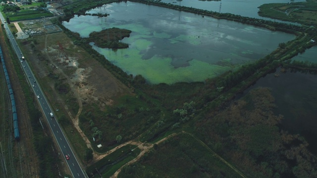 物流业务或运输概念。乡村铁路上成排的货物集装箱和公路上行驶的汽车。视频素材