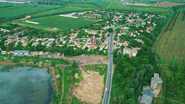 物流业务或运输概念。乡村铁路上成排的货物集装箱和公路上行驶的汽车。视频素材