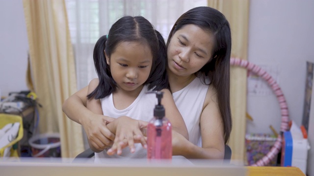 妈妈教女儿用酒精凝胶洗手，用酒精凝胶洗手视频素材