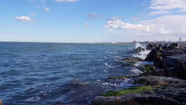 在意大利的海岸上，海浪崩裂成大理石巨石视频素材