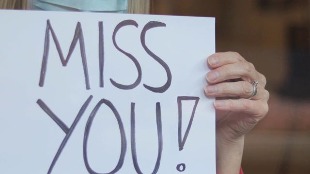 Miss You Sign During Airborne Illness Crisis在空气传播疾病危机中Miss You Sign在空气传播疾病危机中成熟女性避难所在隔离期间在家手持标志4K系列视频视频素材