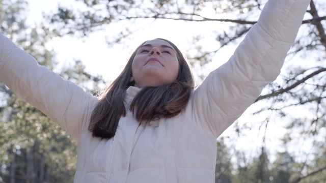 快乐的白人年轻女子在春天的阳光下纺纱。快乐的黑发女孩在户外享受阳光明媚的天气。生活方式，快乐，幸福，休闲。视频素材