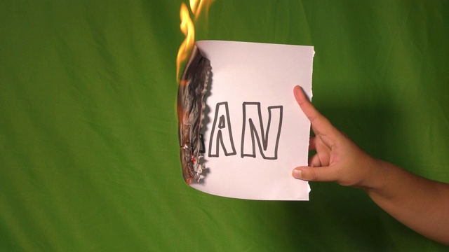 一只手拿着燃烧着的纸，上面写着计划文本。视频素材