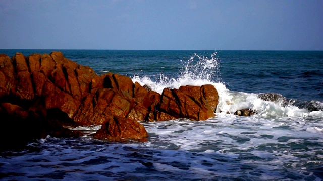 海浪在清澈的海水中拍打着大岩石视频素材