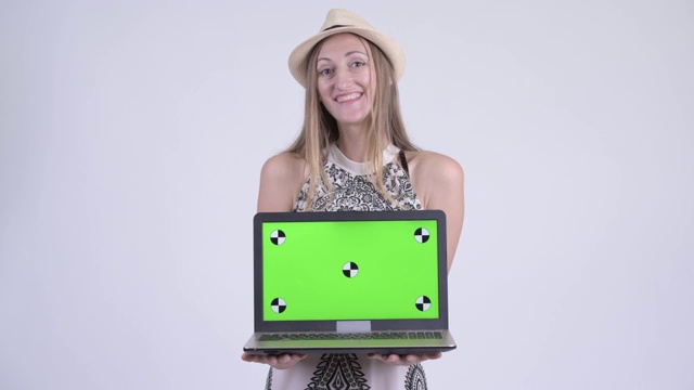 快乐的金发女游客展示笔记本电脑视频素材