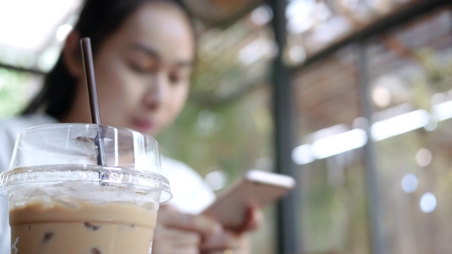 有魅力的女人在假日期间坐在咖啡馆里用智能手机放松。视频素材