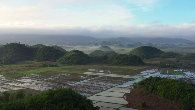 鸟瞰稻田、梯田、农民农地。菲律宾吕宋岛的热带景观和农田。清晨有雾视频素材