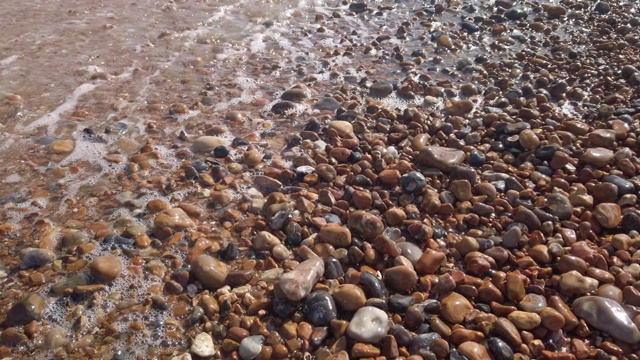 慢镜头缩小在英国布莱顿海滩卵石上的海浪视频下载