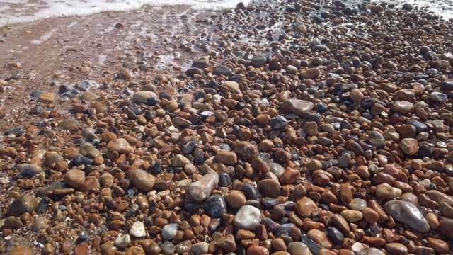 英国布莱顿海滩上的鹅卵石上的慢动作海浪视频下载