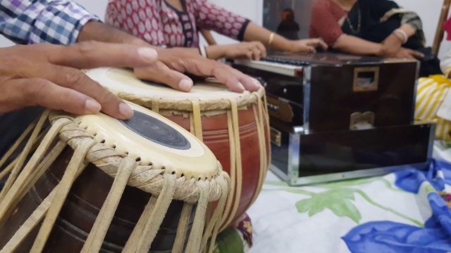 近距离拍摄的双手弹奏印度古典乐器手鼓和弹奏口琴的背景。视频下载