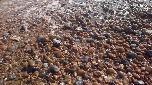 英国布莱顿海滩上的鹅卵石上的慢动作海浪视频下载