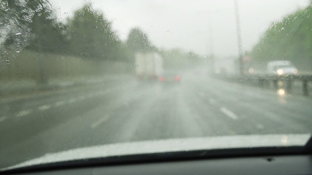 雨中汽车在高速公路上行驶，挡风玻璃上有雨刷视频素材