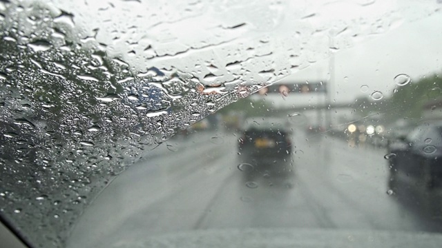 在雨中，汽车在高速公路上行驶，雨刷清除挡风玻璃上的雨滴视频素材