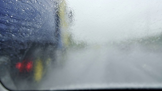 雨中汽车在高速公路上行驶，挡风玻璃上有雨刷视频素材