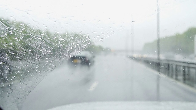 在雨中，汽车在高速公路上行驶，雨刷清除挡风玻璃上的雨滴视频素材