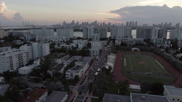 空中倾斜拍摄的体育场在城市的街道与天空，无人机在日落时飞过建筑物-迈阿密，佛罗里达视频素材