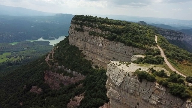 航拍游客在多云的天空下在岩石悬崖上，无人机从岩石山向后飞行在晴朗的一天- Tavertet，西班牙视频素材