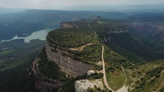 航拍河附近的岩石山在晴朗的一天，无人机向前飞行在自然的绿色景观-塔弗泰，西班牙视频素材