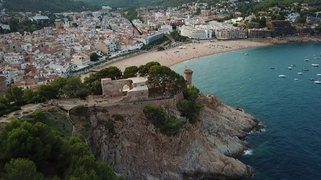 空中倾斜拍摄游客在著名的城堡海上，无人机飞向城市的海滩对山脉- Tossa de Mar，西班牙视频素材