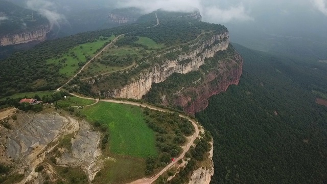 森林中的绿色山峰的航拍，无人机在风景上向前飞行-塔韦泰尔，西班牙视频素材