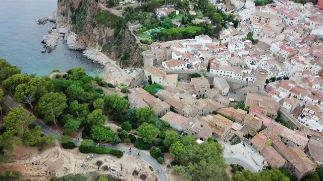 航拍游客在海上岩石形成的历史堡垒，无人机向前飞行在城市- Tossa de Mar，西班牙视频素材