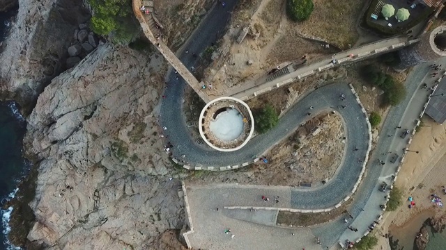 空中俯瞰著名的历史城堡和游客在海上，无人机上升在岩石形成的地标- Tossa de Mar，西班牙视频素材